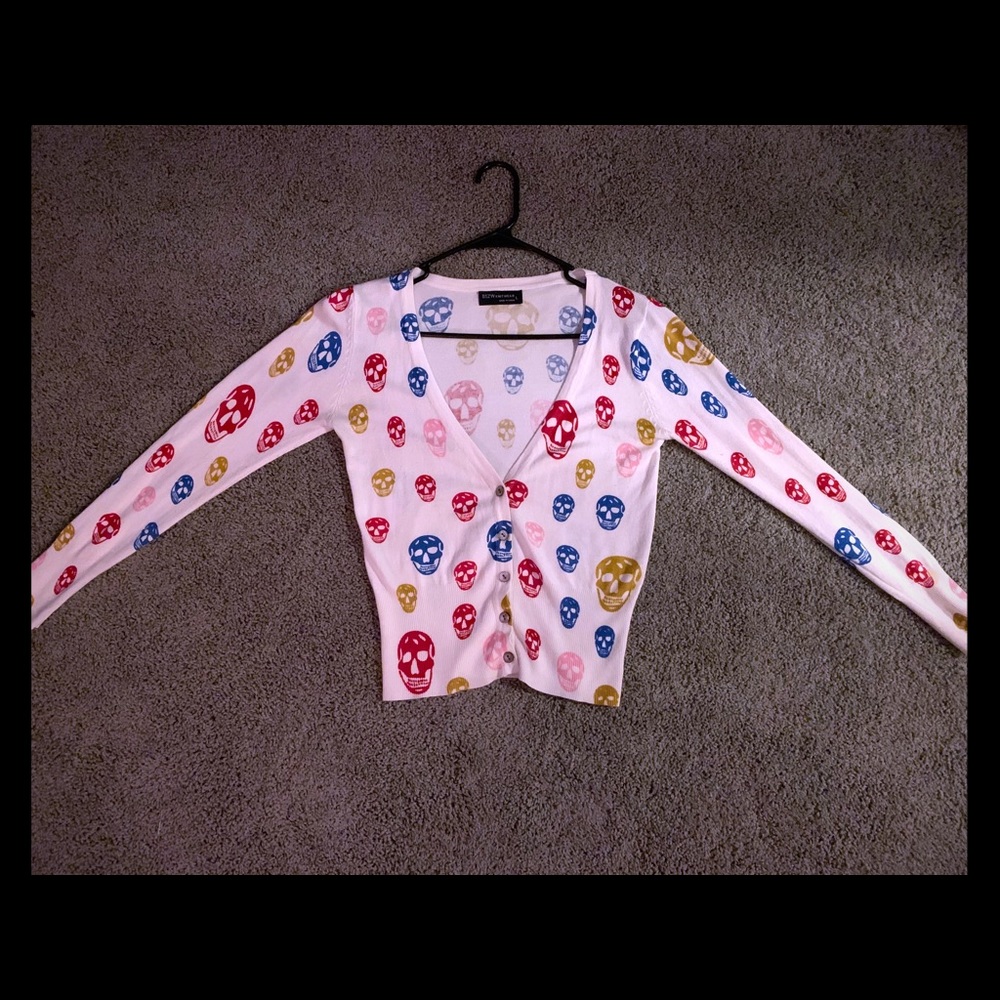 White cardigan with multicolored skull print.